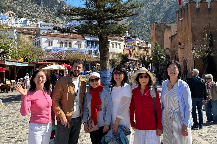 Camel Ride Trips travelers with their guide on Outa el Hammam square and the Kasbah in Chefchaouen, day 2 of the 14-Day Morocco Tour from Casablanca: Morocco at Leisure