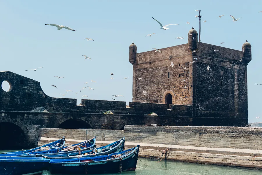 Blue fishing boats below the Skala du Port fortress in Essaouira, day 12 of the 14-Day Morocco Tour from Casablanca: Morocco at Leisure