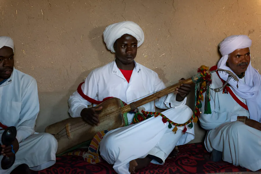 Gnawa musicians playing the guembri in the village of Khamlia near Merzouga, day 7 of the 14-Day Morocco Tour from Casablanca: Morocco at Leisure