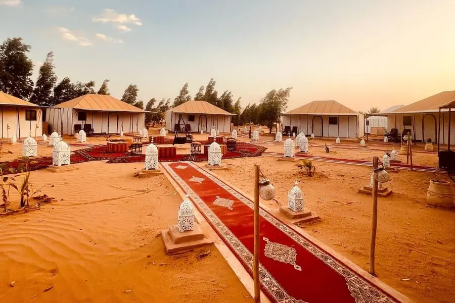 Desert camp with tents, lanterns and carpets in the Erg Chebbi dunes, Merzouga, day 2 of the 4-Day Marrakech to Merzouga Desert Tour