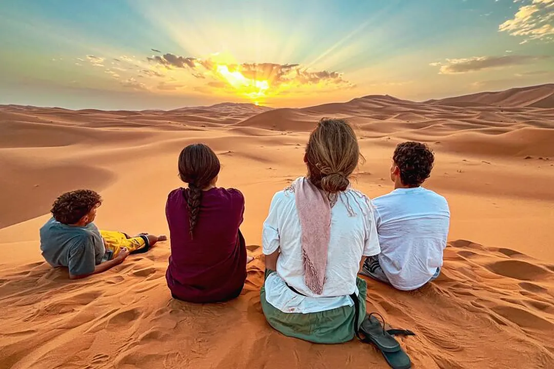 Travelers watching the sunrise over the Erg Chebbi dunes on a relaxed Morocco tour for seniors